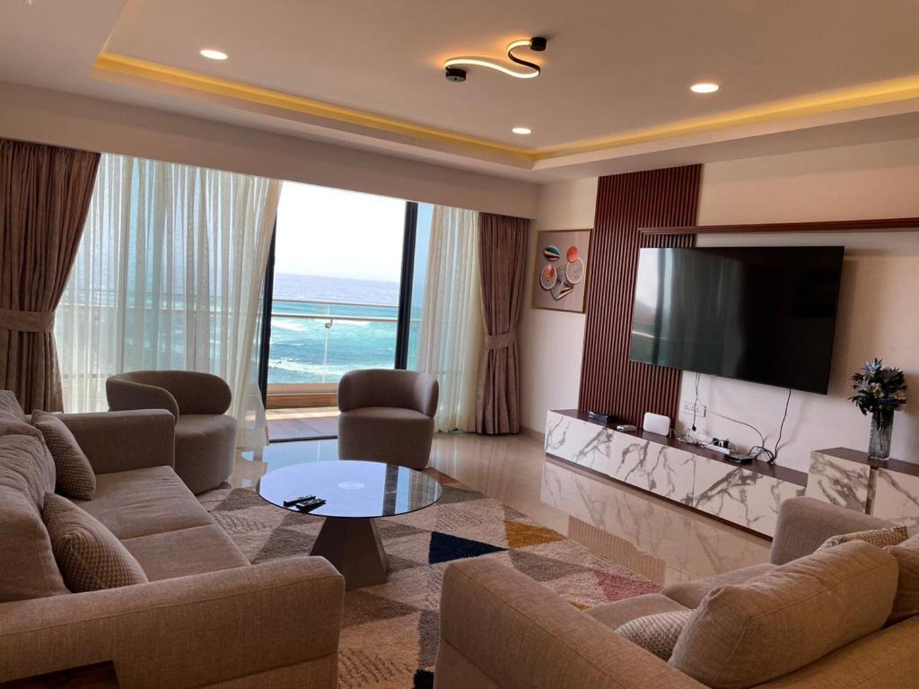 a living room with a television and a couch and a table at Aquanique Luxury Living in Dakar