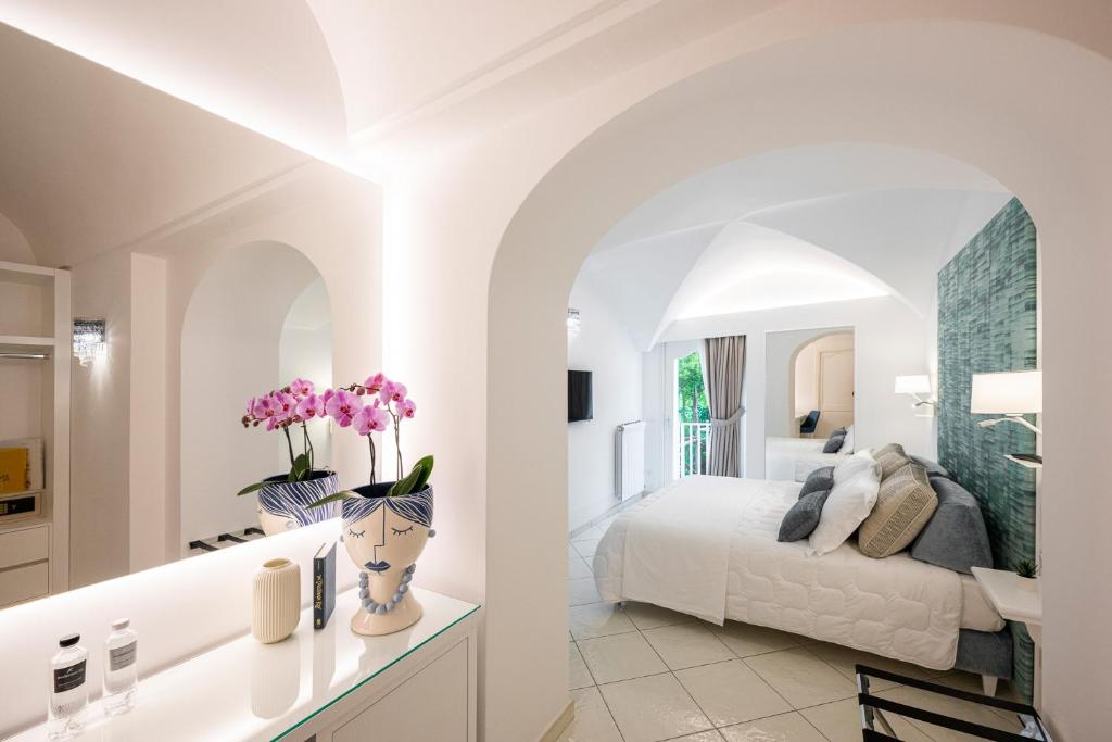 a white bedroom with a bed and a bathroom at La Divina Amalfi Coast in Praiano