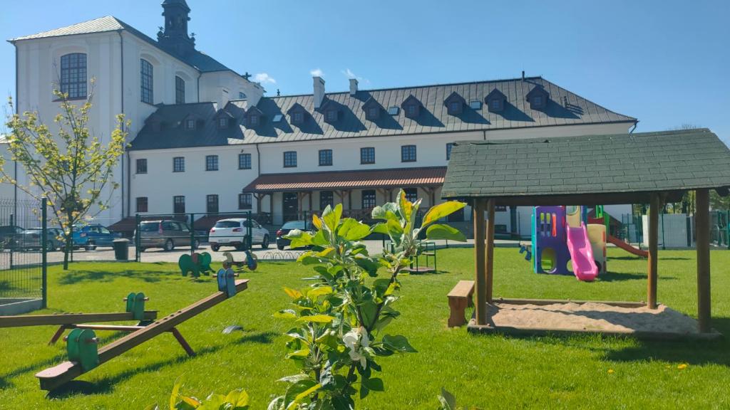 un parco giochi in un parco con un edificio sullo sfondo di Centrum Dialogu Kultur a Węgrów