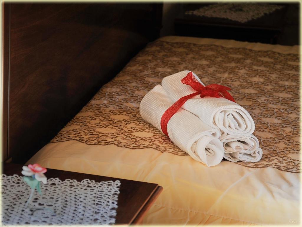 una pila di asciugamani su un letto con un libro di Il Palazzo del Barone - Stanza dei Maiorana a Pietrapertosa