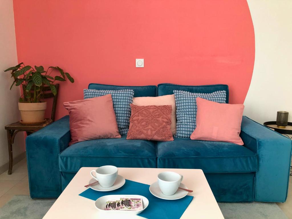 ein blaues Sofa mit Kissen und einen Tisch im Wohnzimmer in der Unterkunft Auterive-Évasions-Éclipse-parking gratuit, hypercentre, gare in Auterive
