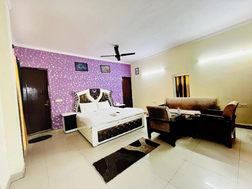 a bedroom with a white bed and a purple wall at Roomshala 167 Hotel Red Near AIIMS in New Delhi
