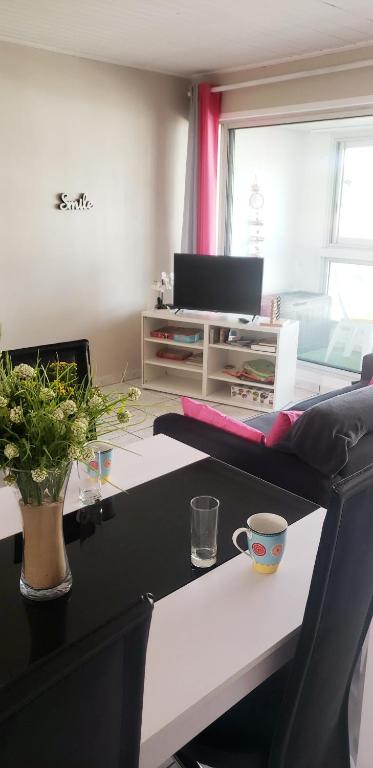 un bureau avec un bureau avec un ordinateur portable et un vase dans l'établissement Appartement spacieux et lumineux Secteur Petit Marché à 5 min a pied de la plage, à Saint-Jean-de-Monts