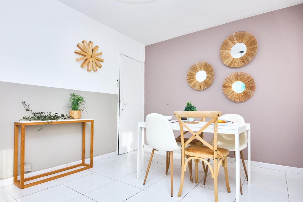 a dining room with a table and chairs and mirrors at Appartement à 10 min de la plage - T4, 9ème in Marseille