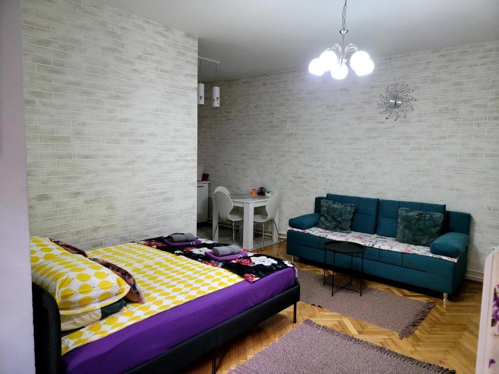 - un salon avec un lit et un canapé dans l'établissement Apartment "GARDEN" on Gundulićeva 8, à Novi Sad