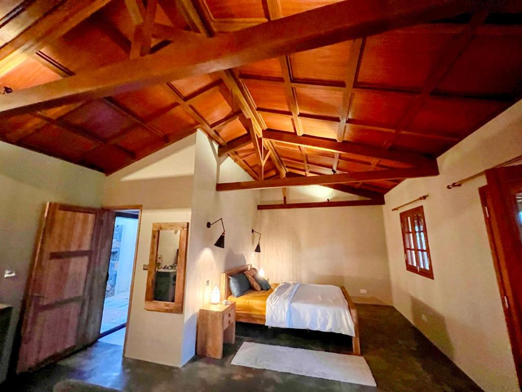 um quarto com uma cama e um tecto de madeira em Lakaz Kannell - Room 1 - Dodo Lodge, secluded outside shower, infinity pool em Cap Malheureux