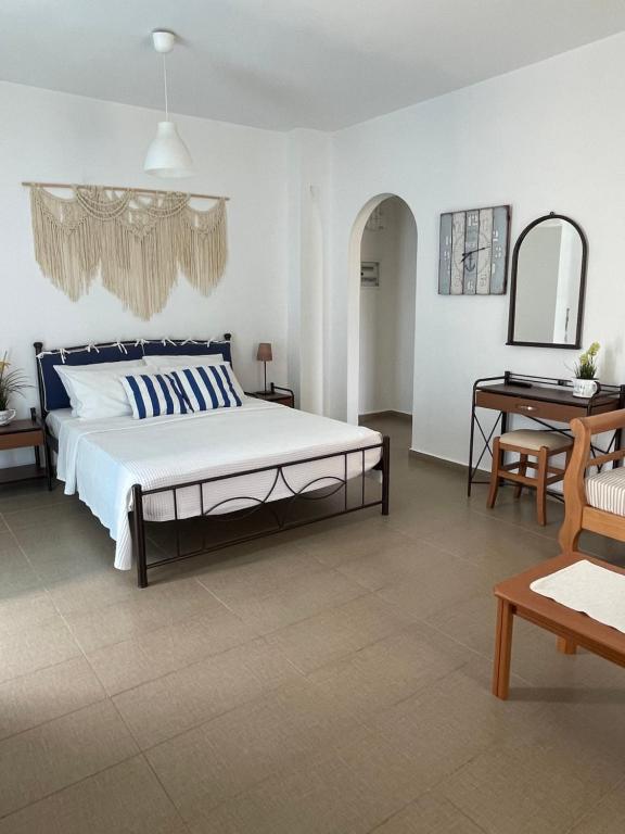 a bedroom with a large bed and a table at Dimora Miranda in Agios Prokopios