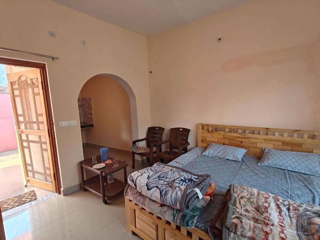 a bedroom with a bed and a table and chairs at Rahgir Guest House in Almora