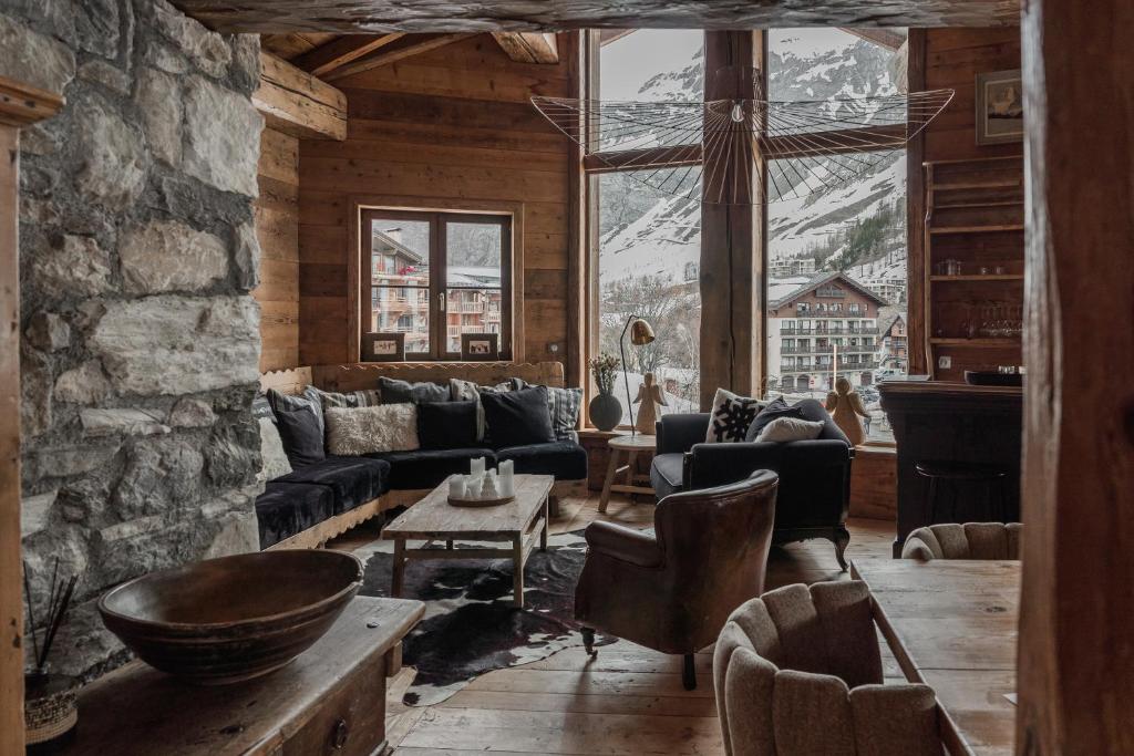 a living room with a couch and a table at Chalet Lièvre Blanc - LES CHALETS COVAREL in Val-d'Isère