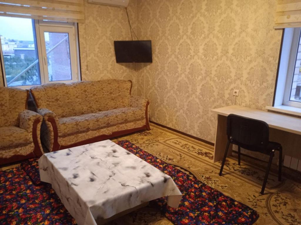 sala de estar con sofá y mesa en Уютная Квартира, en Sergeli