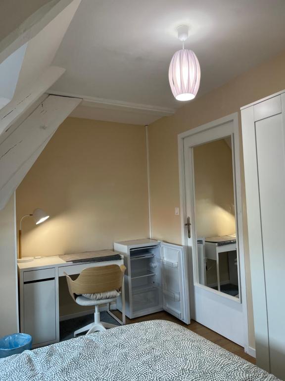 an attic room with a desk and a chair at Chambre privée Coatodon in Guipavas