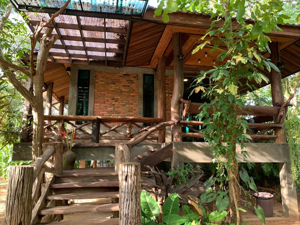 a wooden house with a staircase leading to it at Wooden House Krabi Town in Ban Khlong Chi Lat