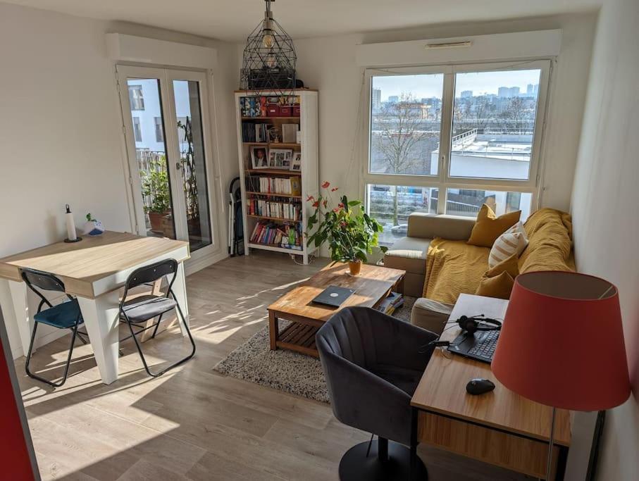 - un salon avec un canapé et une table dans l'établissement Appartement terrasse sur le canal de l’ourcq, à Bobigny
