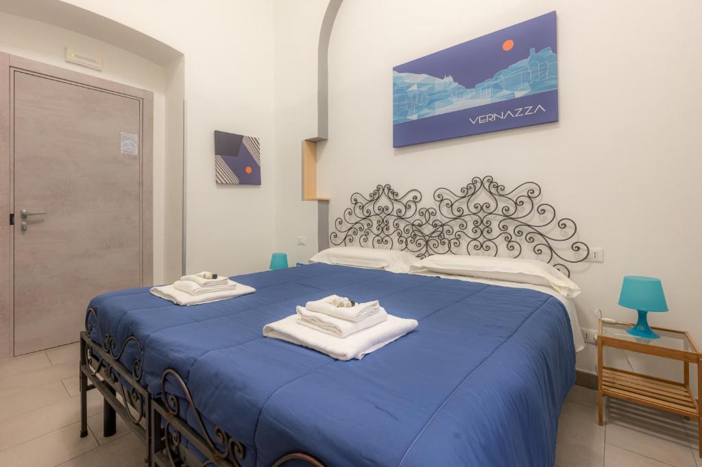 um quarto com uma cama azul com toalhas em Affittacamere del Golfo e delle 5 Terre em La Spezia