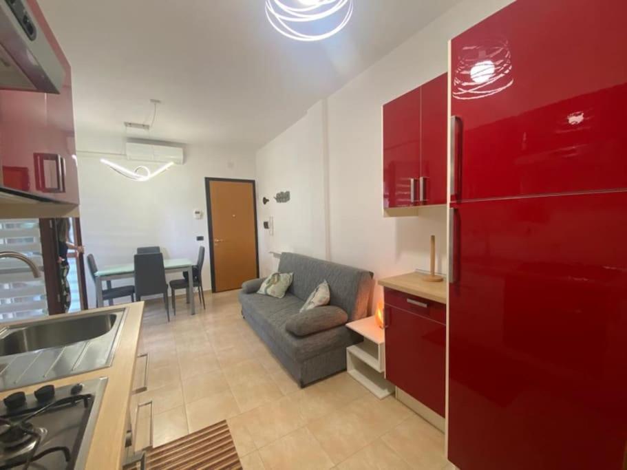 a kitchen and a living room with a couch and a table at Casetta Tommaso in Porto Ercole
