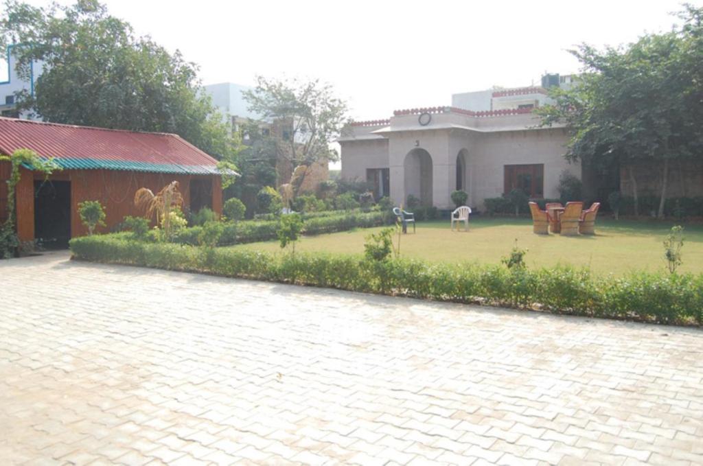 a house with a yard with chairs and a patio at Hotel Comfort Regency in Bharatpur