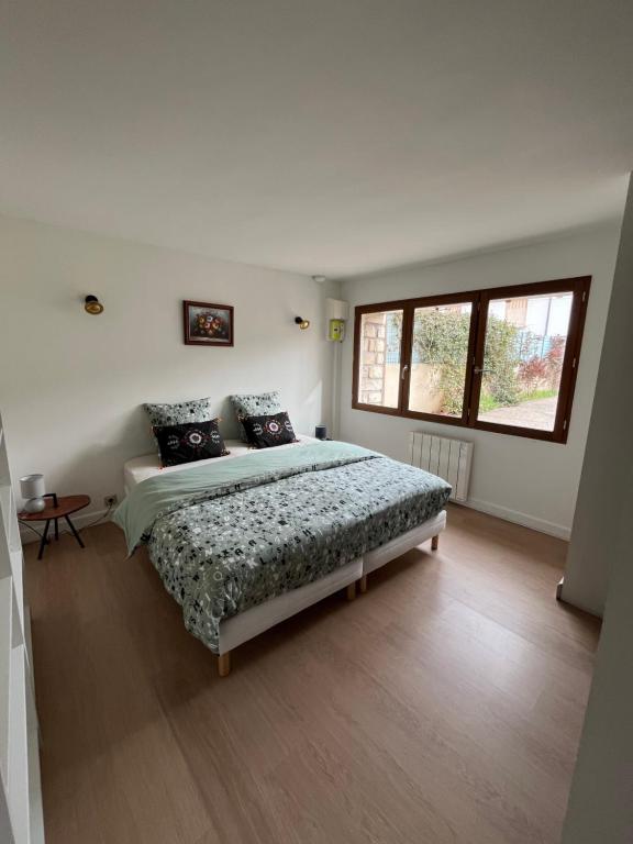 Schlafzimmer mit einem Bett und einem Fenster in der Unterkunft Maison familiale 3 chambres in Avignon