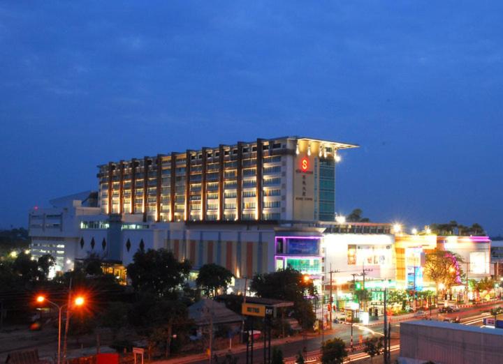 Sunee Grand Hotel and Convention Center في أوبون راتشاثاني: مبنى مضاء في مدينة في الليل