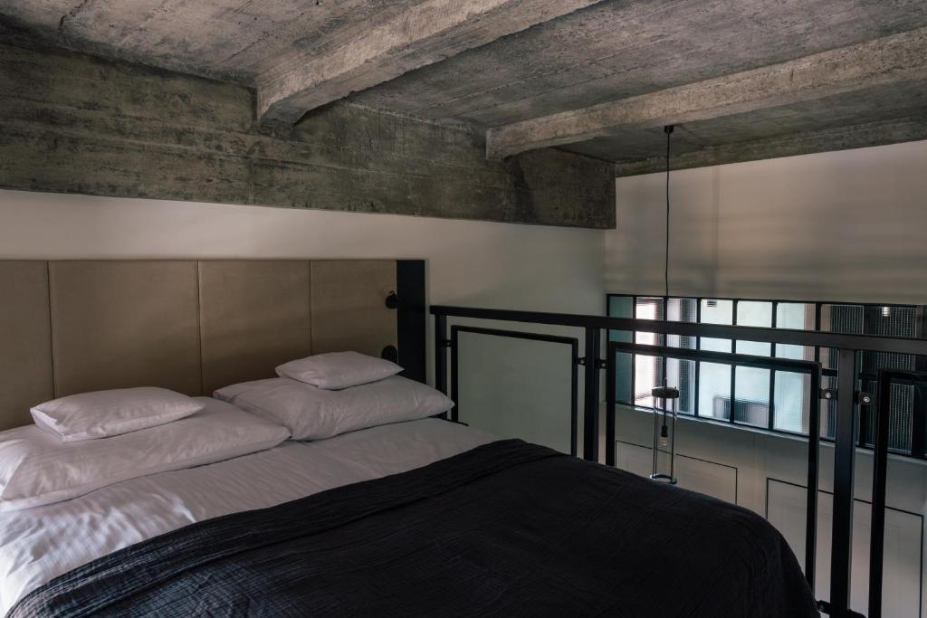 1 dormitorio con 1 cama grande con sábanas blancas en 4 Strony Apartamenty w Wodnej Wieży, en Pszczyna