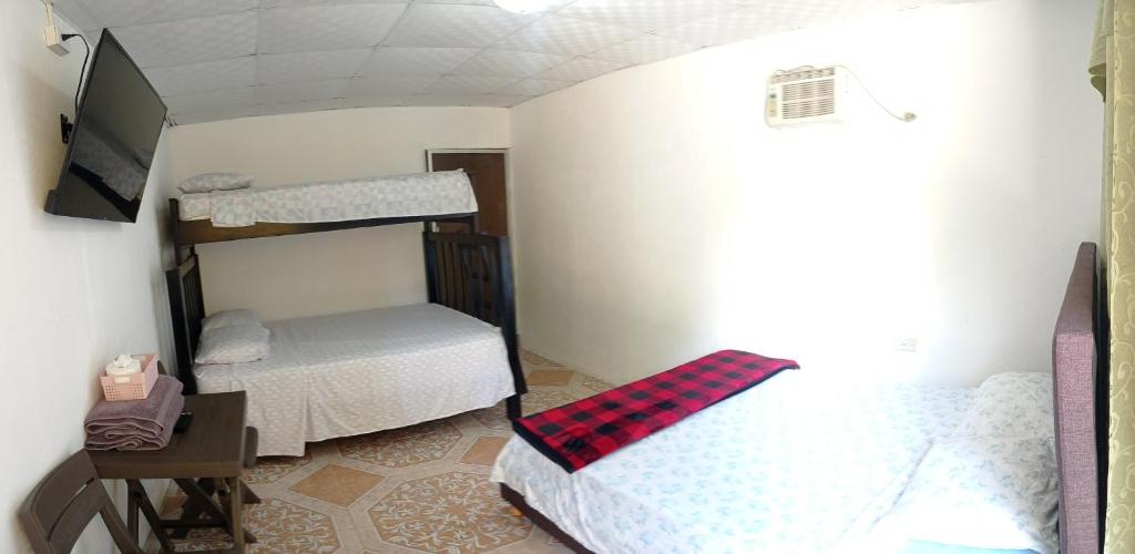 een kamer met 2 stapelbedden en een televisie bij Tres Monos Hotel, Restaurante, Piscina, Bar in Limones