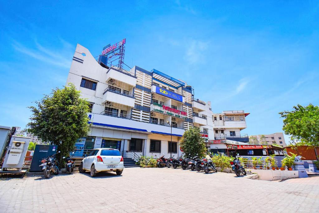 a white car parked in front of a building at Via Yashraj Inn in Vagholi