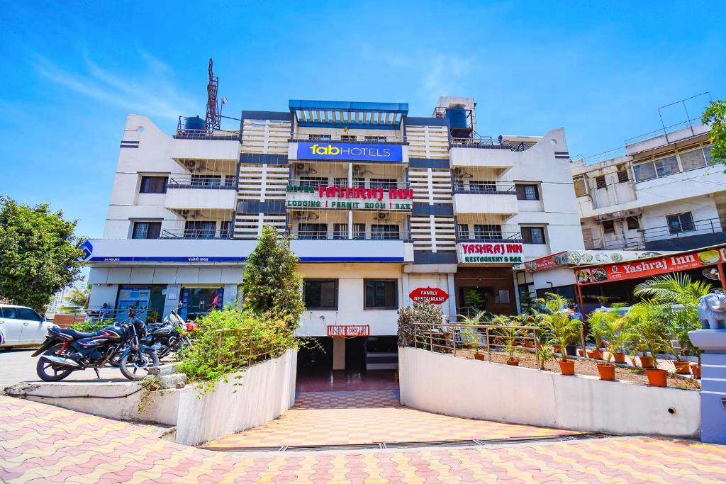 un bâtiment avec des motos garées devant lui dans l'établissement FabHotel Yashraj Inn, à Vagholi