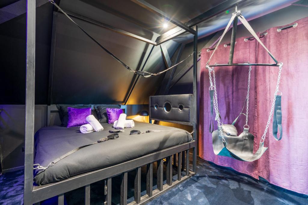um quarto com uma cama com um baloiço em LoverDose by Les Gîtes du Moul1 em Duppigheim