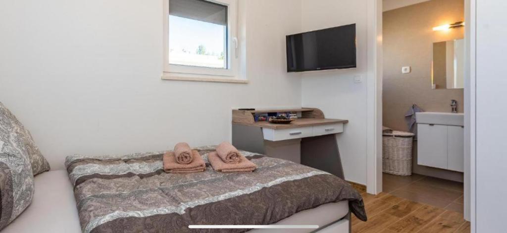 een slaapkamer met een bed met twee slippers erop bij Villa Tara in Srima