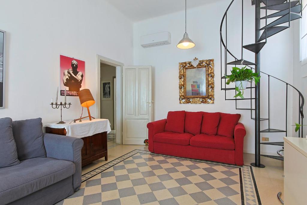 a living room with a red couch and a chair at B&B Cristina e Stefano in Pisa