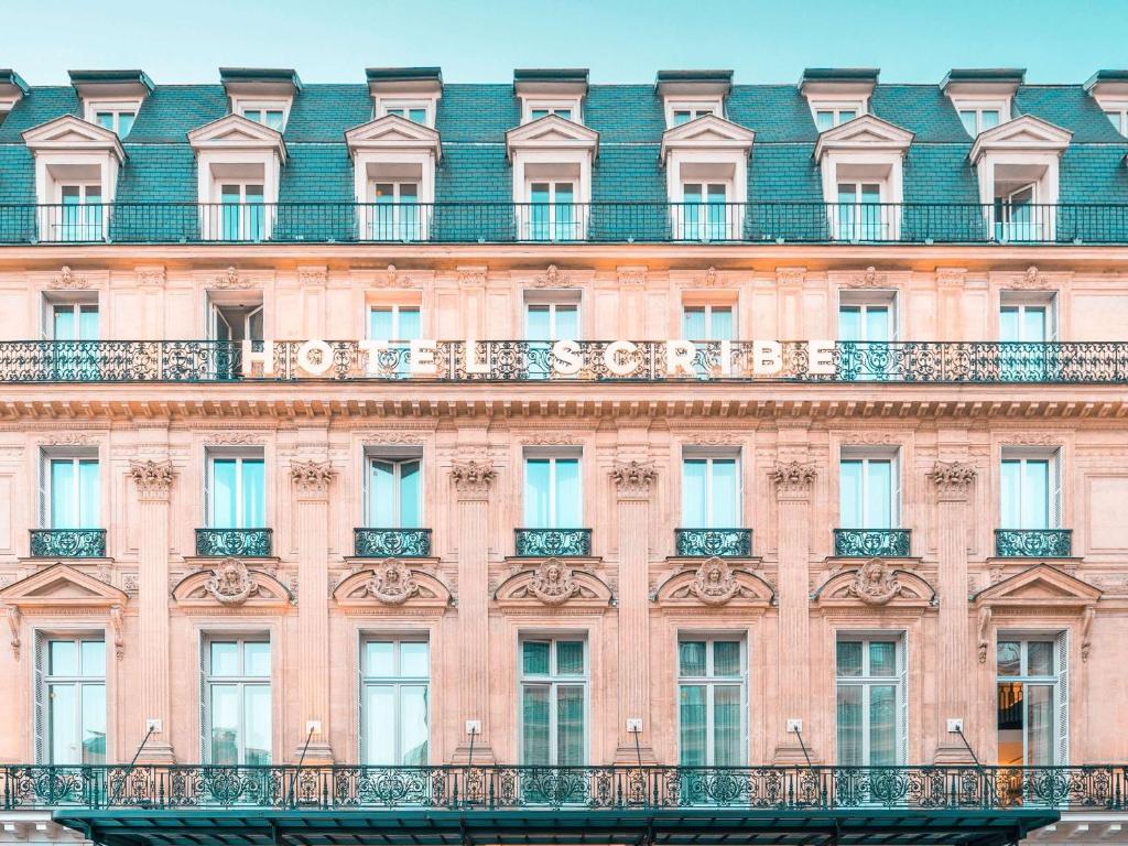 a facade of a large pink building with windows at Sofitel Le Scribe Paris Opera in Paris
