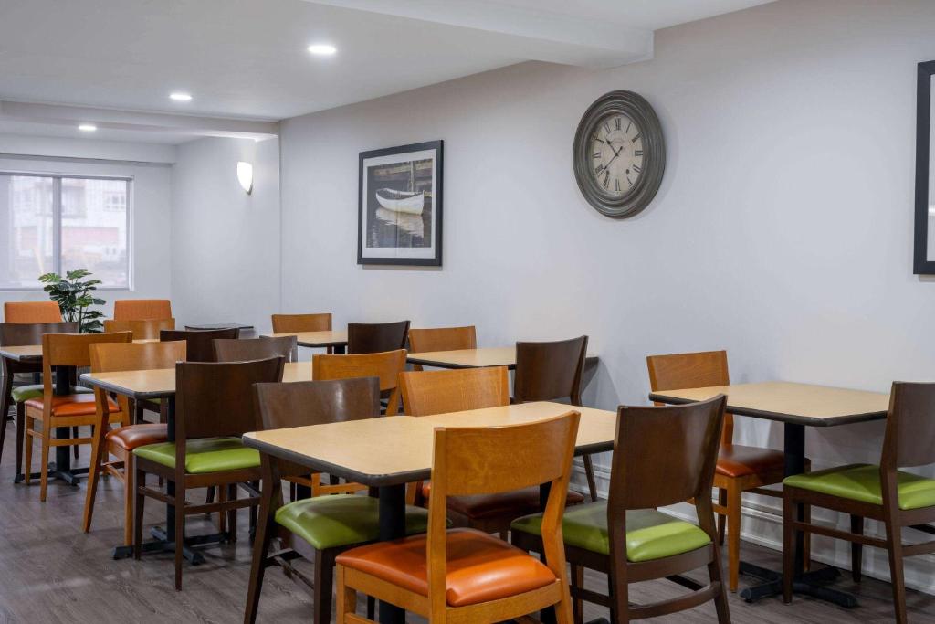 a dining room with tables and chairs and a clock at Travelodge Suites by Wyndham Saint John in Saint John