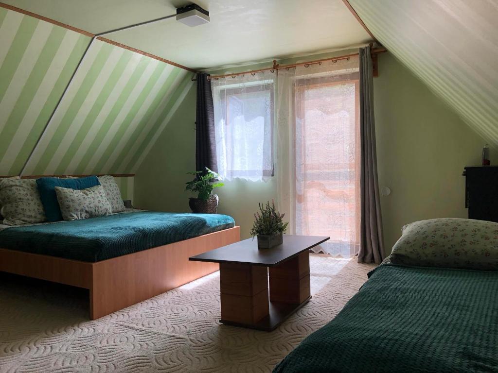 Schlafzimmer mit einem Bett, einem Tisch und einem Fenster in der Unterkunft Váradi Vendégház in Doboz