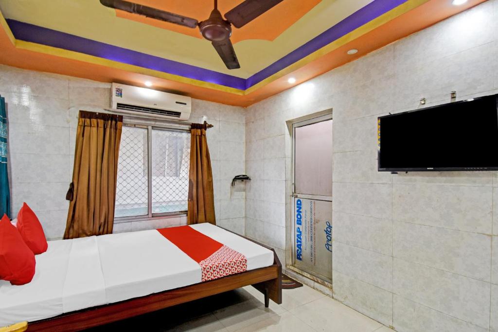 a bedroom with a bed and a flat screen tv at OYO Flagship The Rest in Gauripur