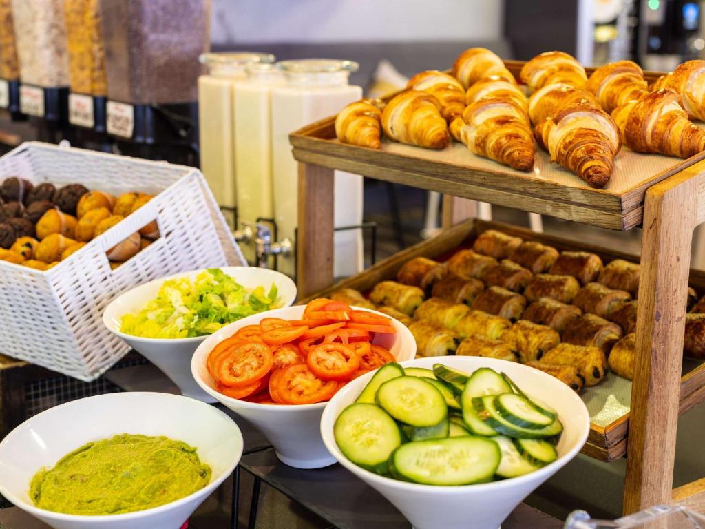 a buffet of food with bowls of vegetables and bread at ibis London City - Shoreditch in London