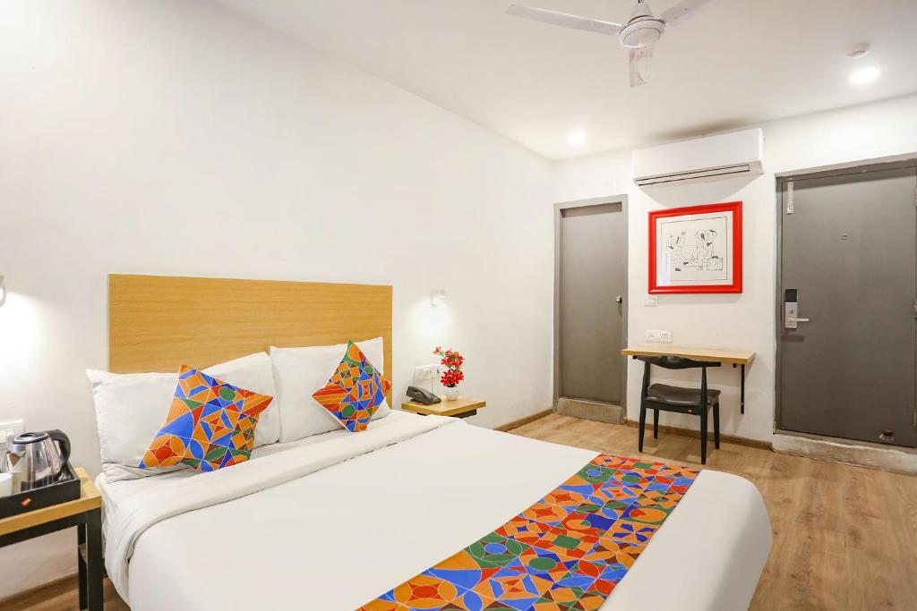 a hotel room with a large bed and a desk at FabHotel Vivek in Muthiganj
