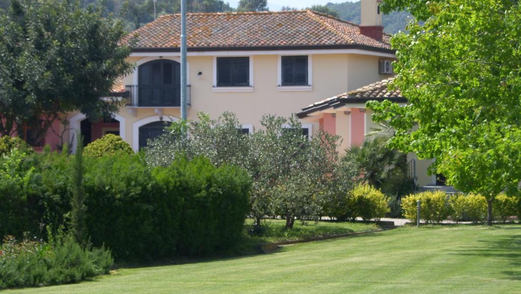 ein großes Haus mit einem Rasen davor in der Unterkunft Bari Sardo Le More Suite 1 in Bari Sardo