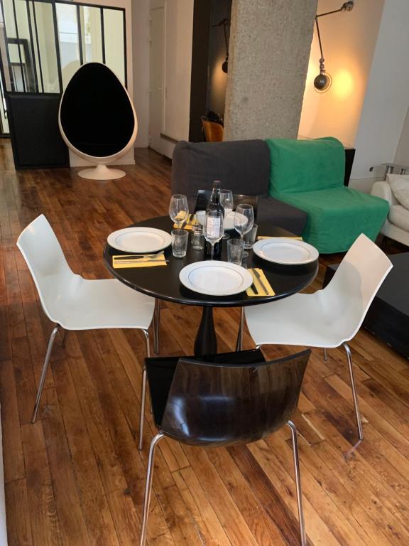 - un salon avec une table et des chaises dans l'établissement loft Montmartre au pieds des vignes, à Paris