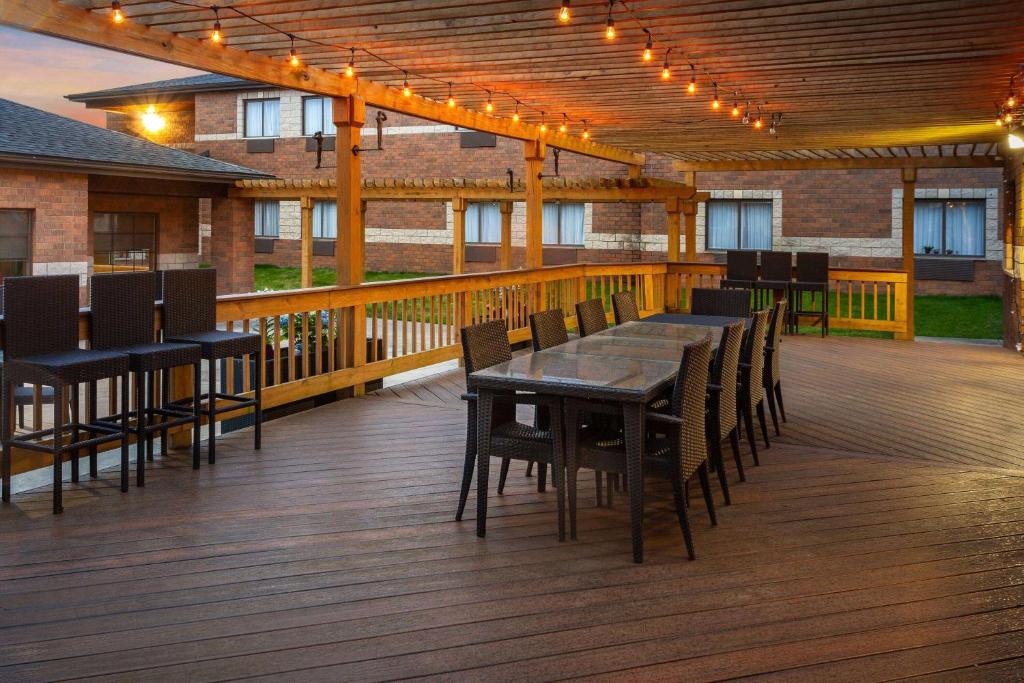 a wooden deck with tables and chairs and lights at Baymont by Wyndham Copley Akron in Copley