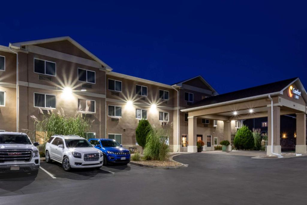un hotel con coches estacionados en un estacionamiento en Comfort Inn Fort Morgan, en Fort Morgan