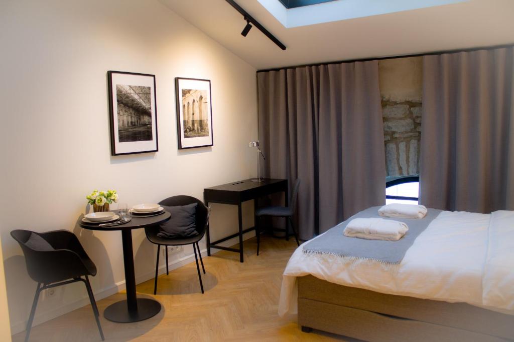- une chambre avec un lit, une table et un bureau dans l'établissement Kalamaja Loft Apartments, à Tallinn
