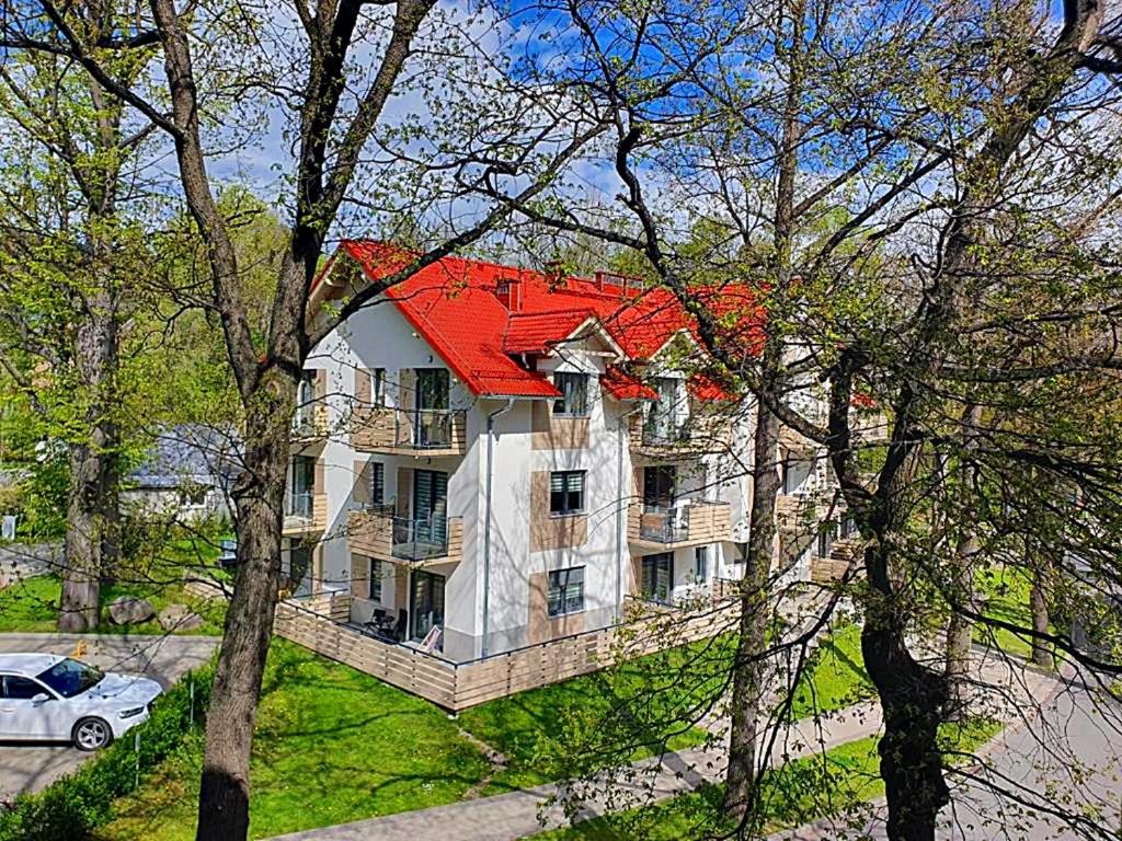 カルパチにあるApartamenty Rezydencja Pod Dębami Sun&Fun - blisko centrumの赤屋根の大白屋敷