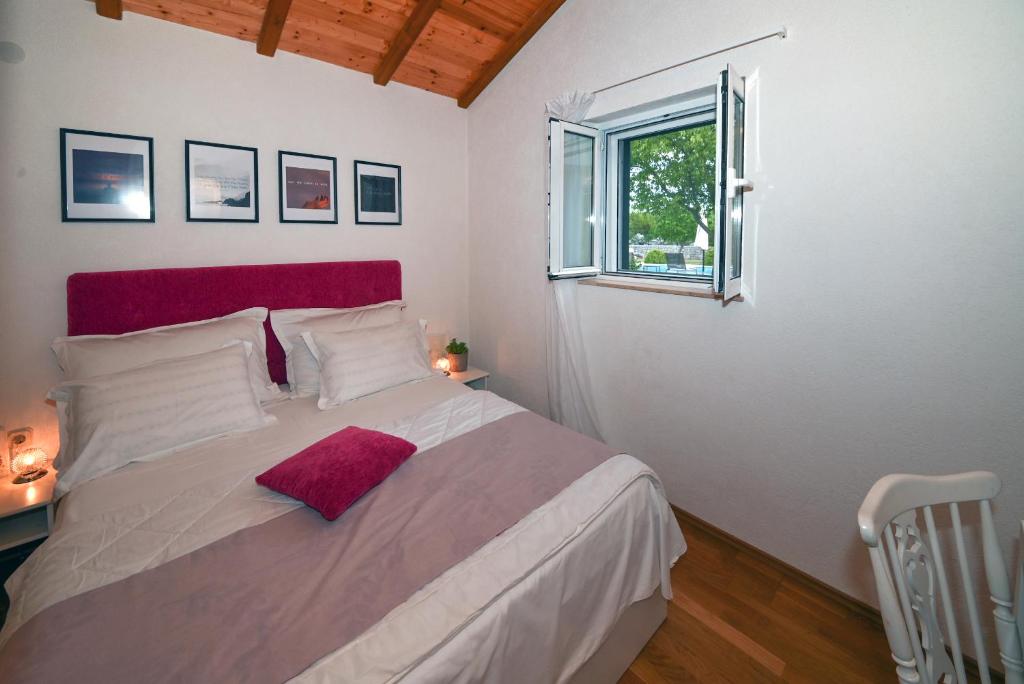 sypialnia z dużym łóżkiem z czerwonym zagłówkiem w obiekcie Villa Silentio, complete privacy near Makarska w mieście Duge Njive