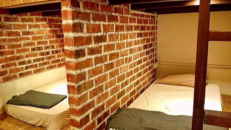 a bedroom with two bunk beds in a brick wall at Quiver Dive Team Perhentian Dorm in Perhentian Island