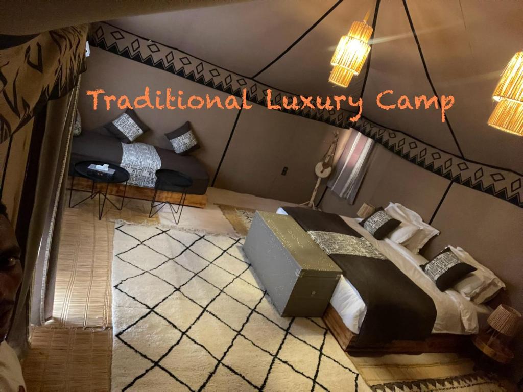 AdrouineにあるTraditional Luxury Campのベッド2台付きの部屋、伝統的な豪華なキャンプを読む看板