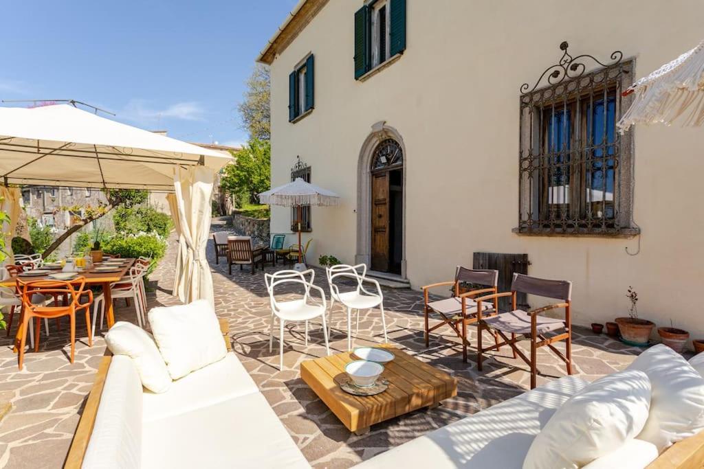 Elle comprend une terrasse dotée d'un mobilier blanc, d'une table et de chaises. dans l'établissement gite 6 chambres en Toscane, à Serrazzano
