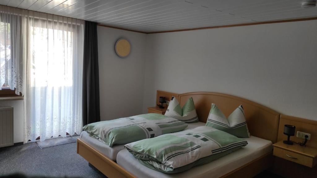 Gasthof Zur Goldenen Sonne في Remptendorf: غرفة نوم عليها سرير ومخدات خضراء