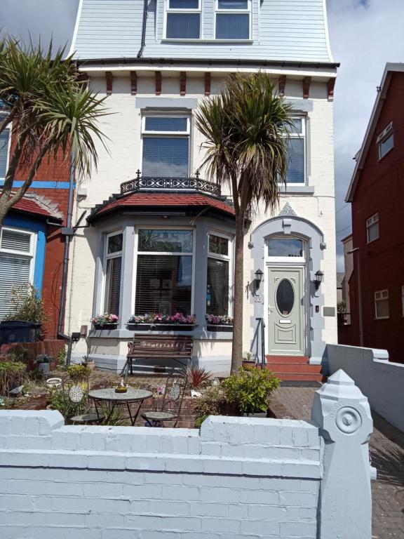 a white house with palm trees in front of it at Heather Lea Guest Rooms in Blackpool