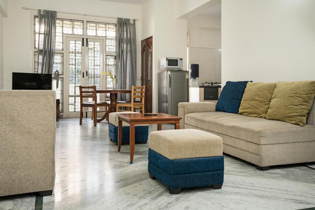 uma sala de estar com um sofá e uma mesa em Aishwarya Mystic Apartotel em Bangalore