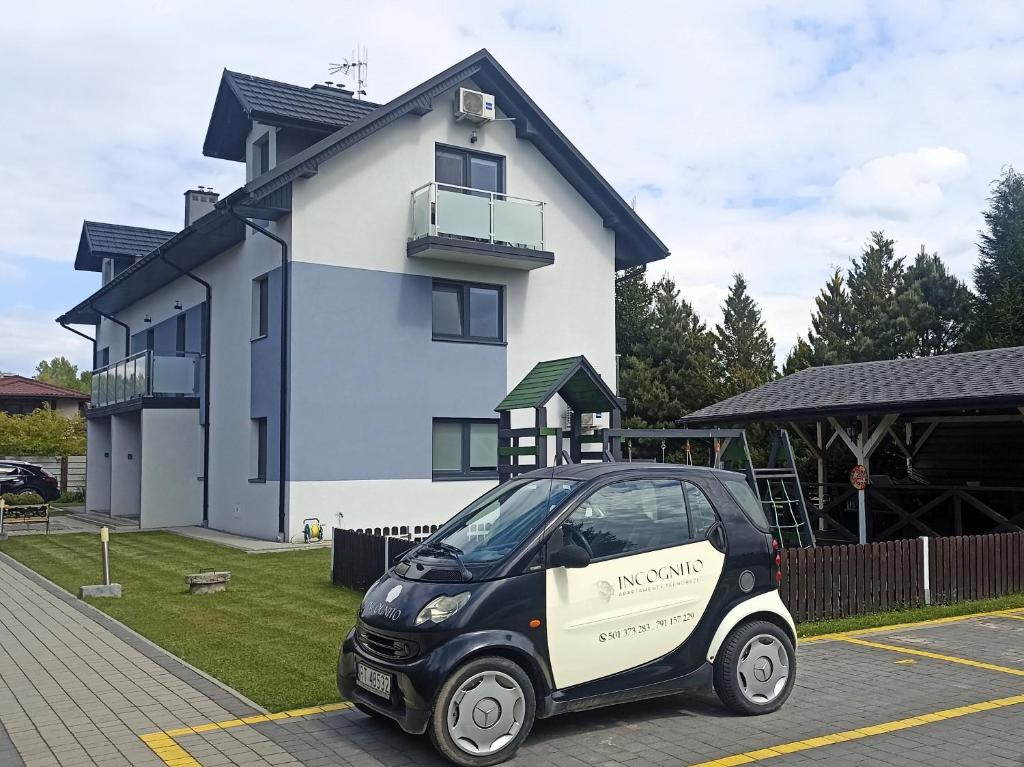 a smart car parked in front of a house at Apartamenty INCOGNITO Jezioro Tarnobrzeg in Tarnobrzeg