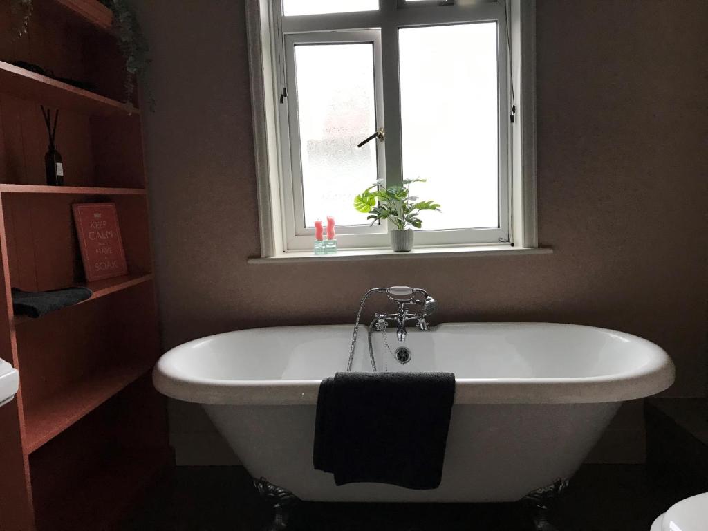 a white bath tub in a bathroom with a window at The Snug in Fordingbridge